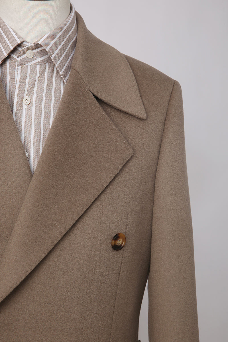 Brown coat on a mannequin with a striped shirt underneath against a plain background