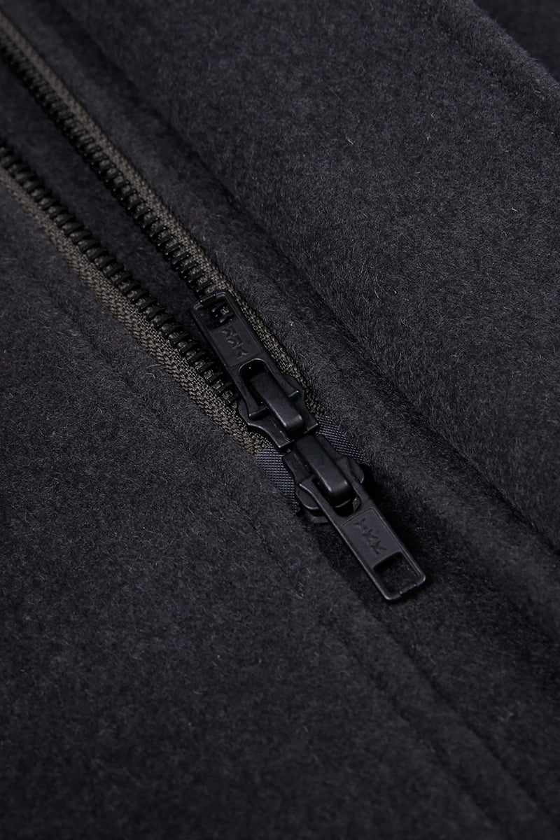 Close-up of a black zipper on a textured black fabric background
