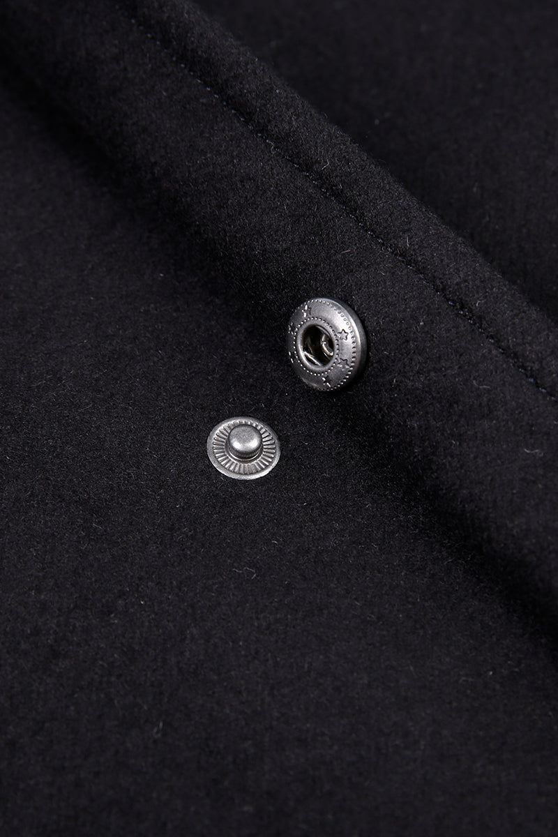 Close-up of a black fabric surface with two silver buttons.