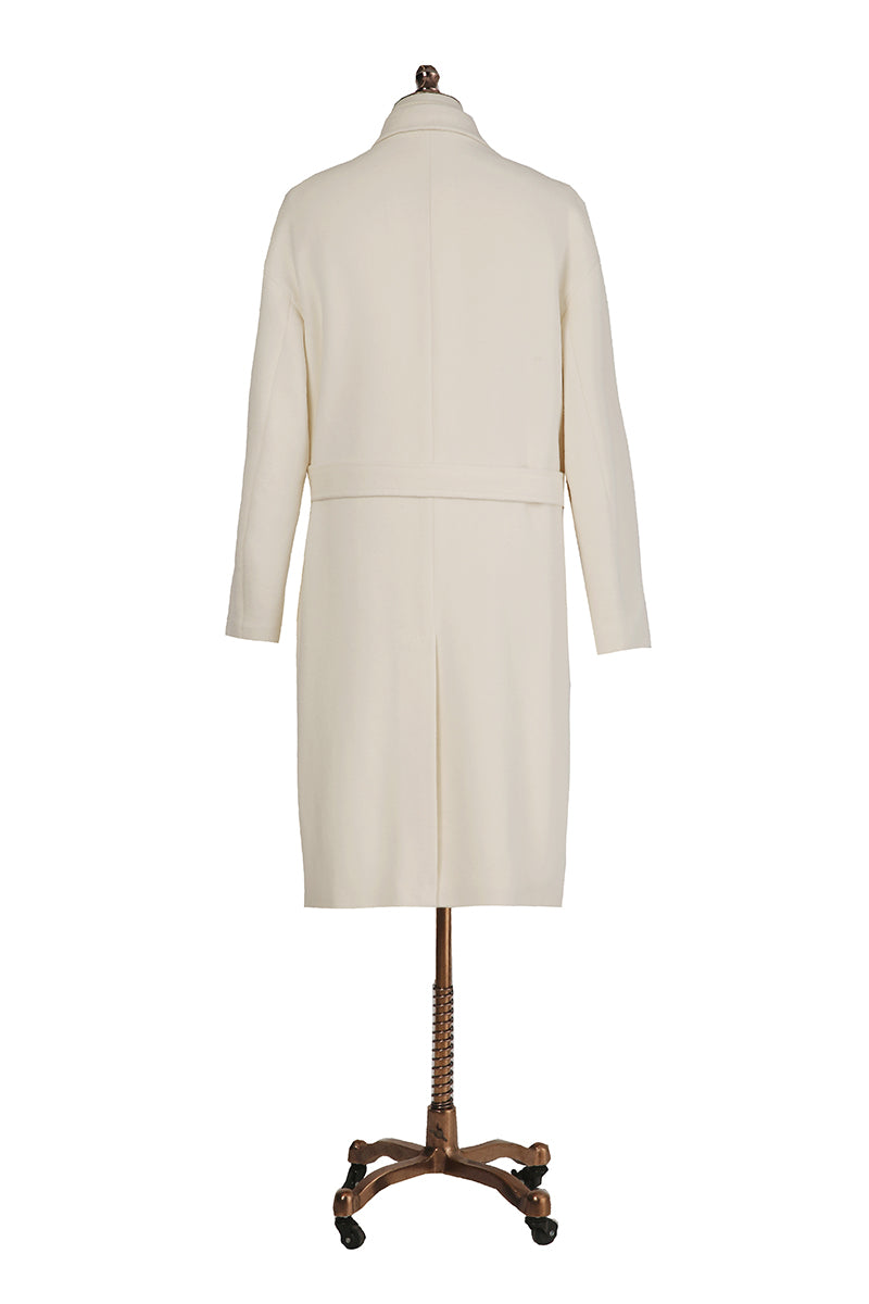 White coat on a mannequin with a wooden base against a white background