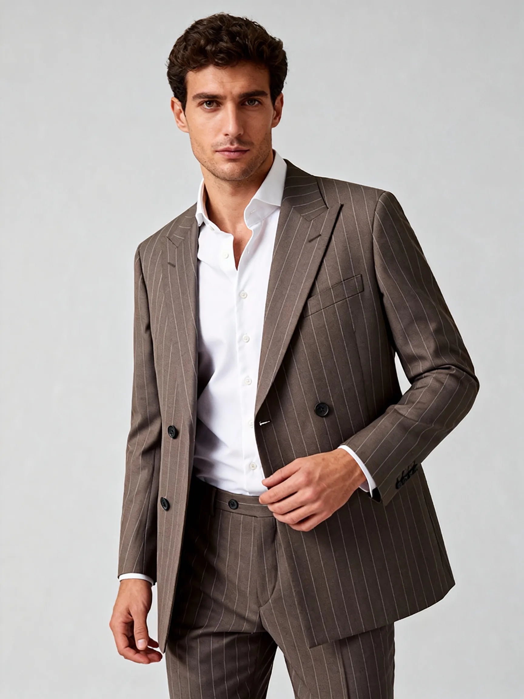 Man wearing a brown pinstripe suit with a white shirt on a light gray wool blend suit bespoke itailored suit