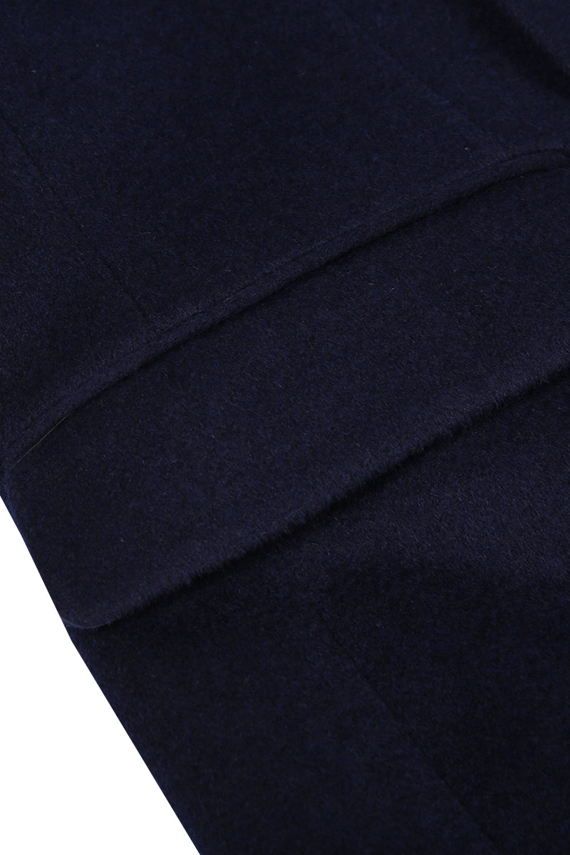 Close-up of a navy blue fabric with a pocket detail on a white background