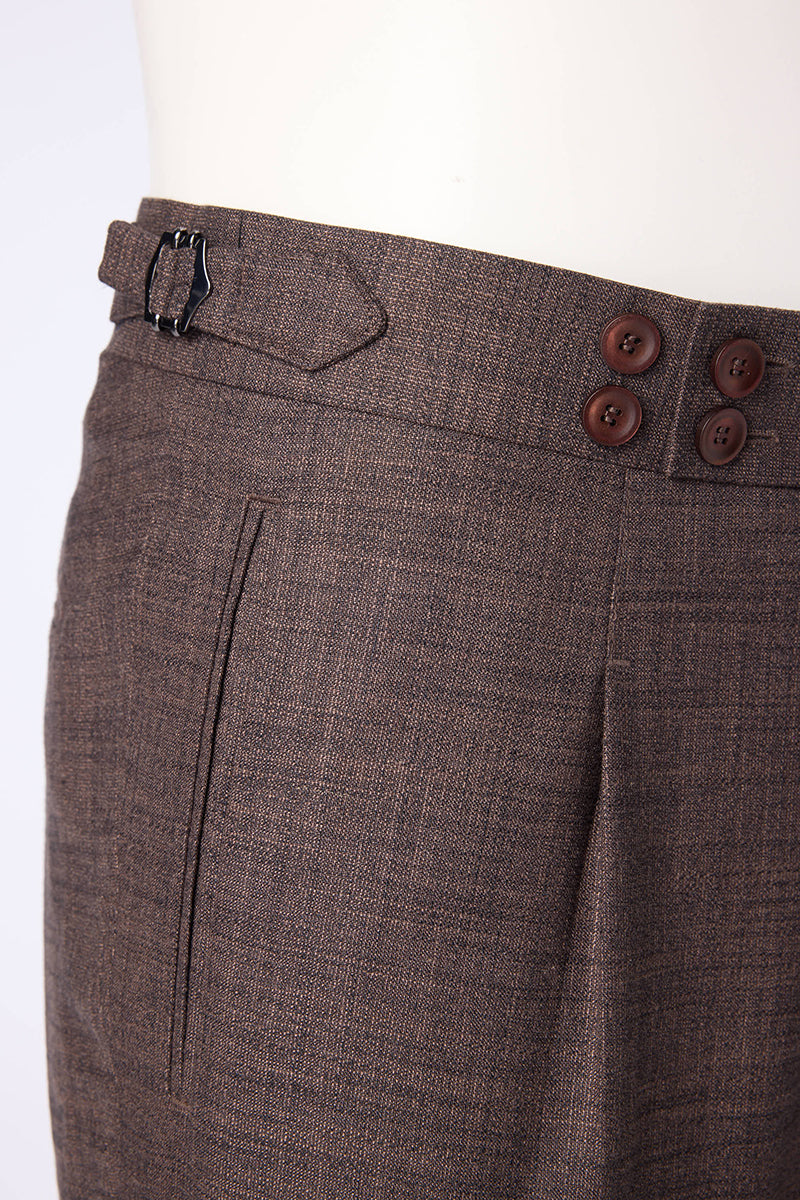 Men's brown textured dress pants featuring a pleated front design, side waist adjusters, and an extended button tab closure for a tailored, polished look. Crafted from a luxurious blend of bamboo, wool, silk, and spandex, these trousers offer natural stretch, breathability, and a soft drape, making them ideal for formal business settings, wedding attire, or upscale casual events. Styled to pair seamlessly with blazers, dress shirts, or knitwear, these pants are perfect for the modern gentleman seeking versa
