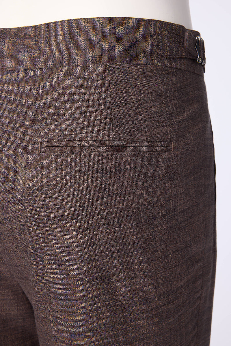 Men's brown textured dress pants featuring a pleated front design, side waist adjusters, and an extended button tab closure for a tailored, polished look. Crafted from a luxurious blend of bamboo, wool, silk, and spandex, these trousers offer natural stretch, breathability, and a soft drape, making them ideal for formal business settings, wedding attire, or upscale casual events. Styled to pair seamlessly with blazers, dress shirts, or knitwear, these pants are perfect for the modern gentleman seeking versa