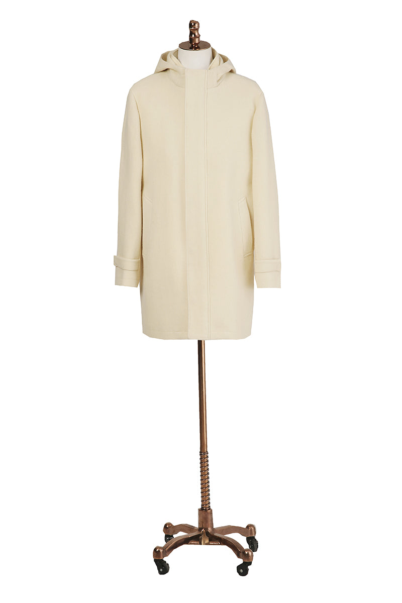 Beige coat on a mannequin with a decorative base against a white background