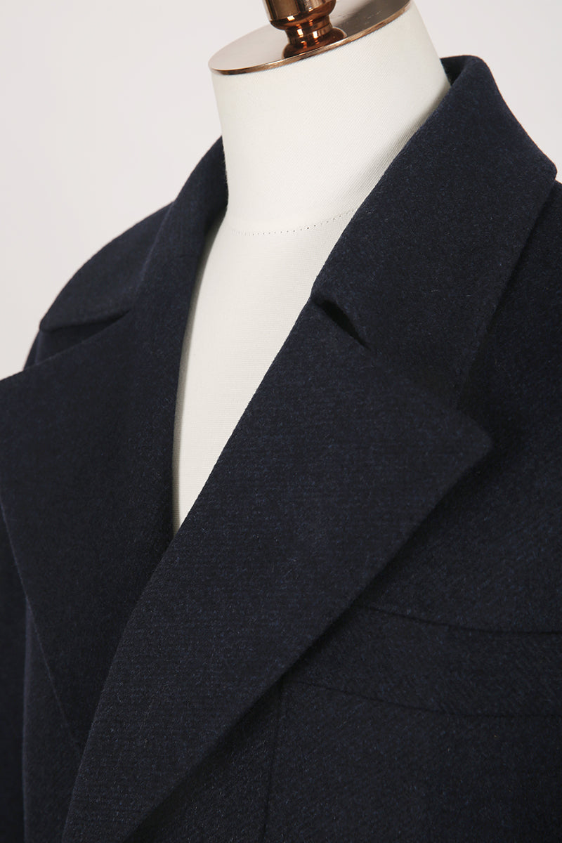 Navy blue coat on a mannequin against a white background