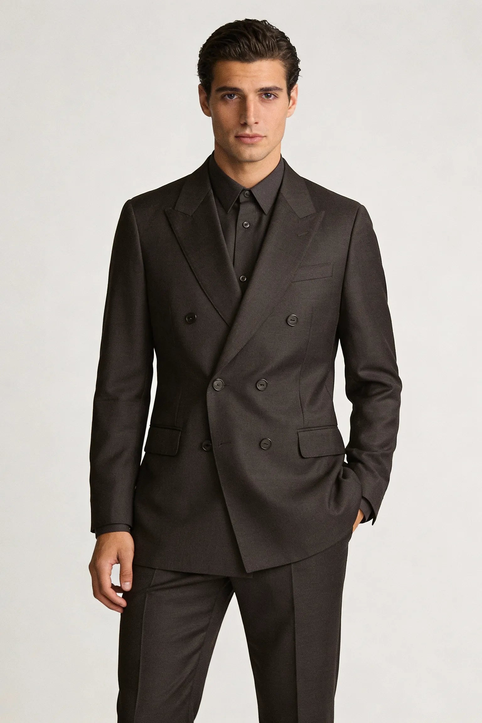 Man wearing a dark brown suit on a white background italian suit custom tailored 