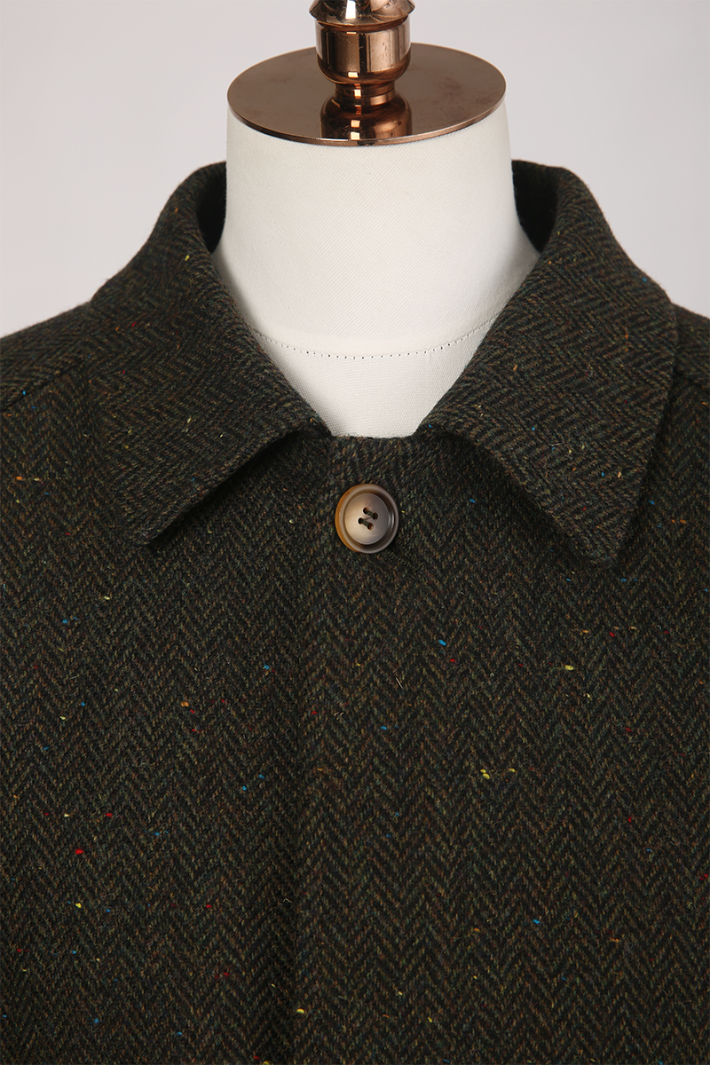 Dark herringbone patterned coat on a mannequin with a white background
